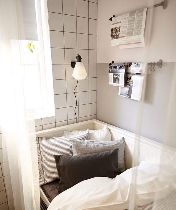 A sofa-bed in a kitchen, all set for bedtime. The curtain is drawn to act as a room divider.
