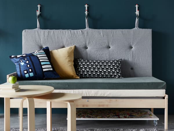 A sofa made from mattresses with the backrest hanging on wall hooks
