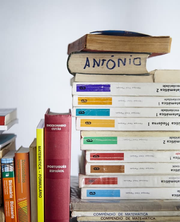 A stack of books with different colours on the spines add a personal touch to this white bedroom.