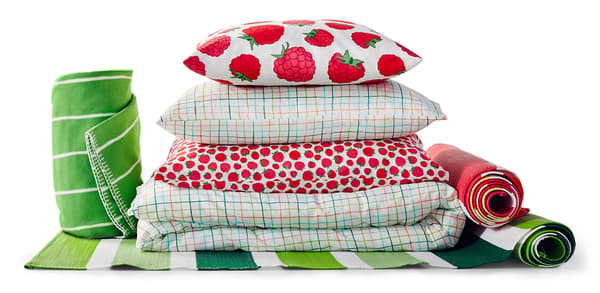 A stack of pillows, duvets, towels and rugs.