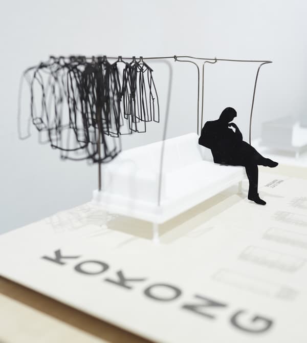 A student with a miniature model of the DELAKTIG sofa.