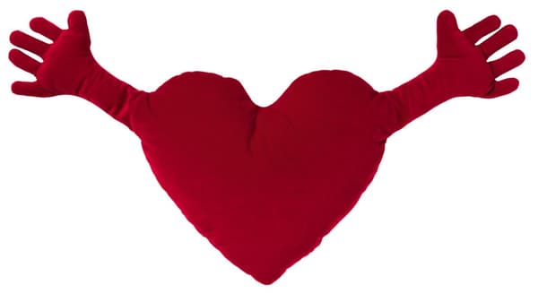 A stuffed heart pillow with two arms extended for a hug