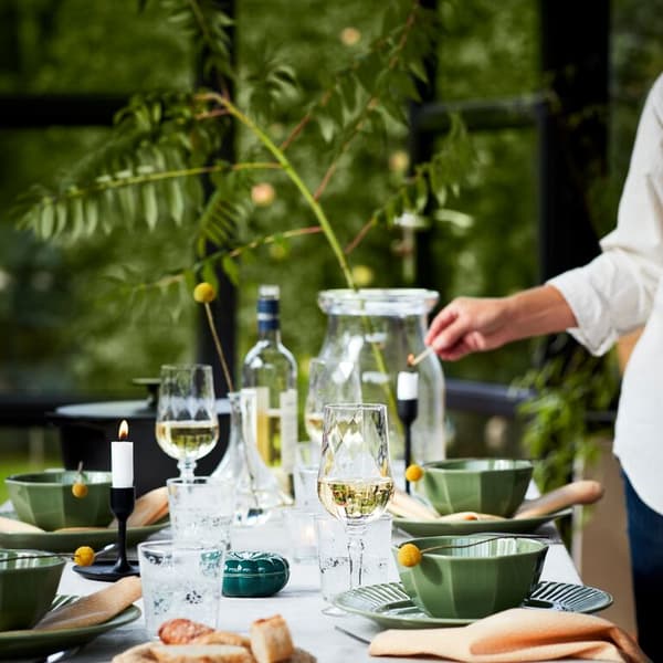 A table set for entertaining with MUSTIGHET glassware and STRIMMIG tableware.