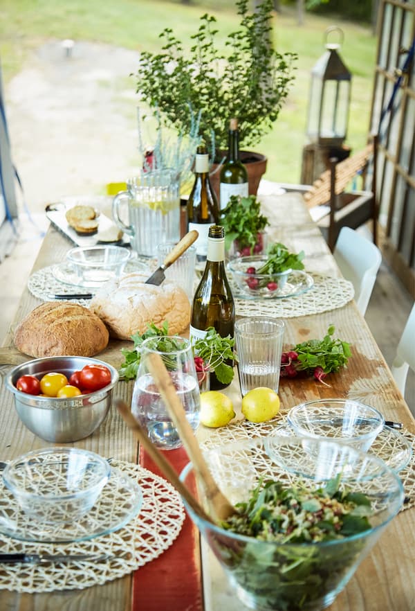 A table set with salads and plants.