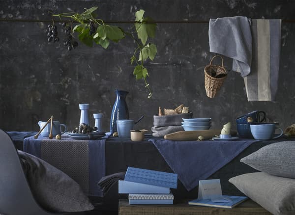 A table setting with ceramics and textiles in a blue colour palette.