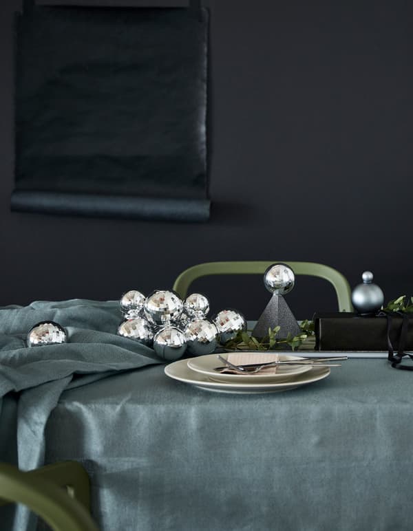 A table setting with silver baubles and repurposed gift boxes.
