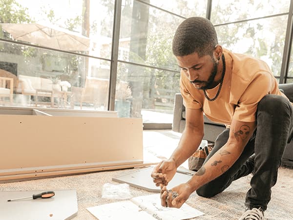 A tasker assembling IKEA furniture in a client's home.