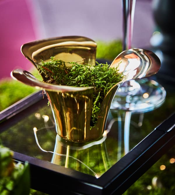 A tea light holder is filled with moss.