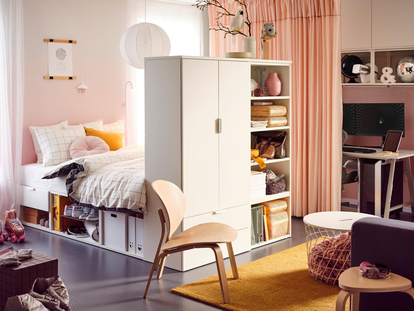 A teen bedroom with a PLATSA bed frame with objects and baskets on the shelves at the end and a yellow rug on the floor.
