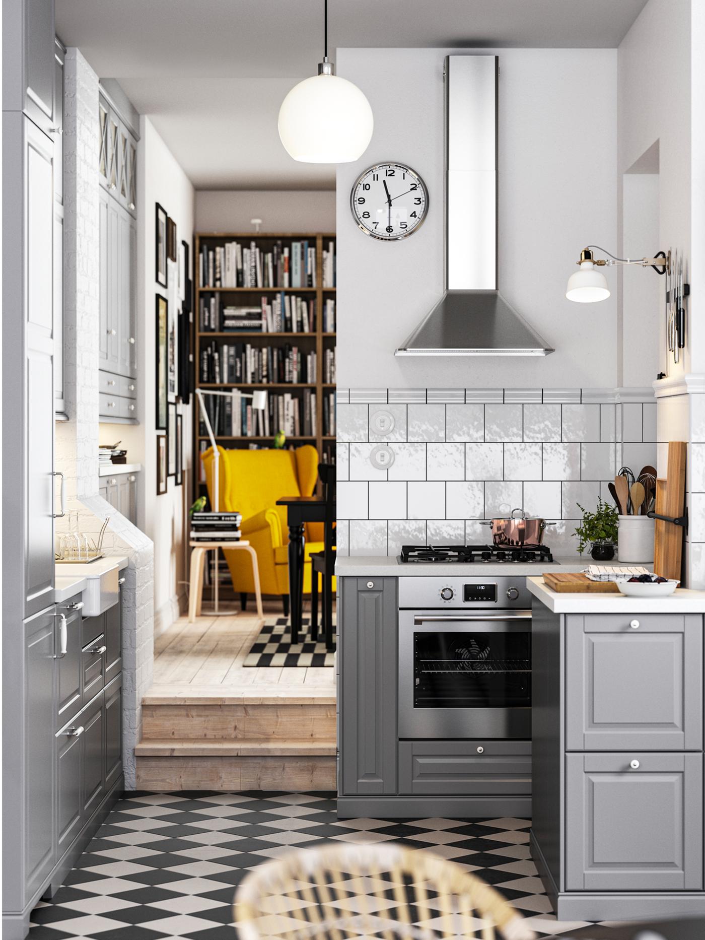 A traditional kitchen with a chequered floor, grey BODBYN kitchen fronts and white/light grey stone effect/laminate worktops.