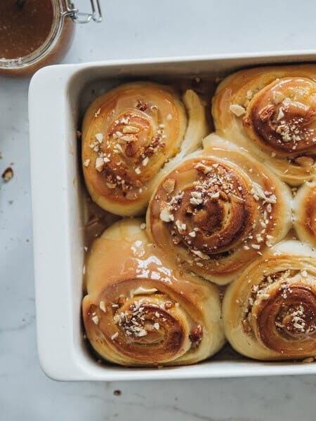 A tray with freshly baked vegan apple cider caramel yeast knots.