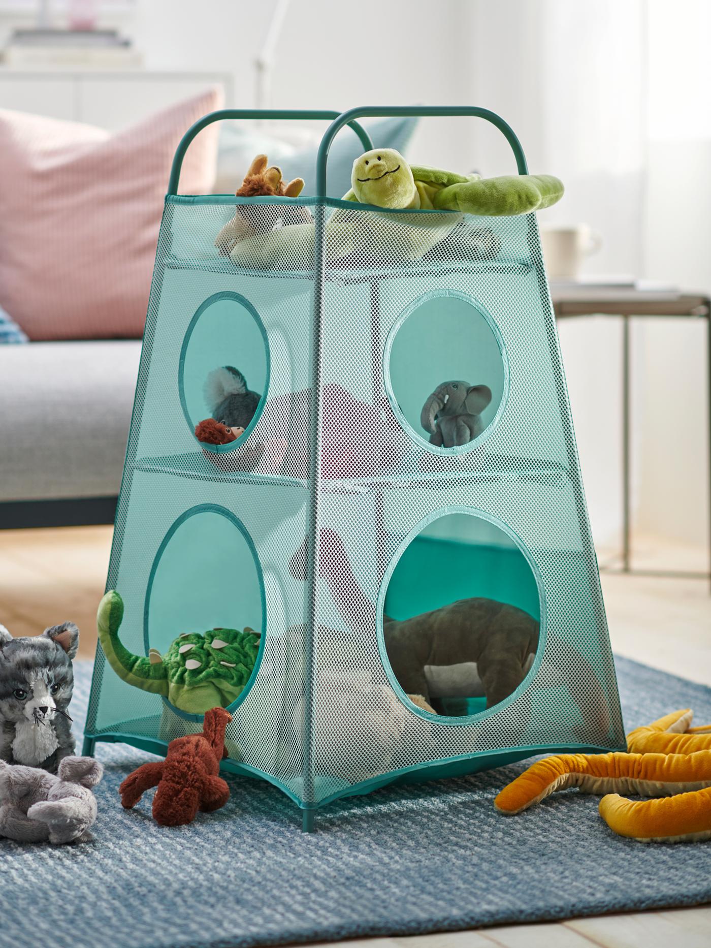 A turquoise TIGERFINK storage with compartments filled with stuffed toys is on alight blue rug in a living room.