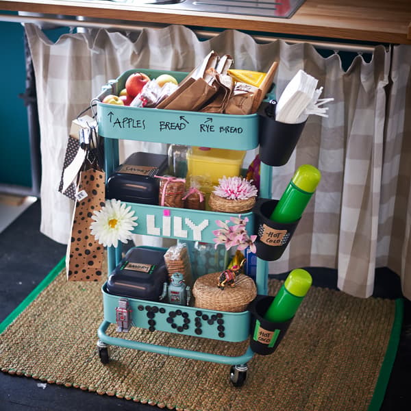A turquoise trolley used to store content for lunch packages for kids. 