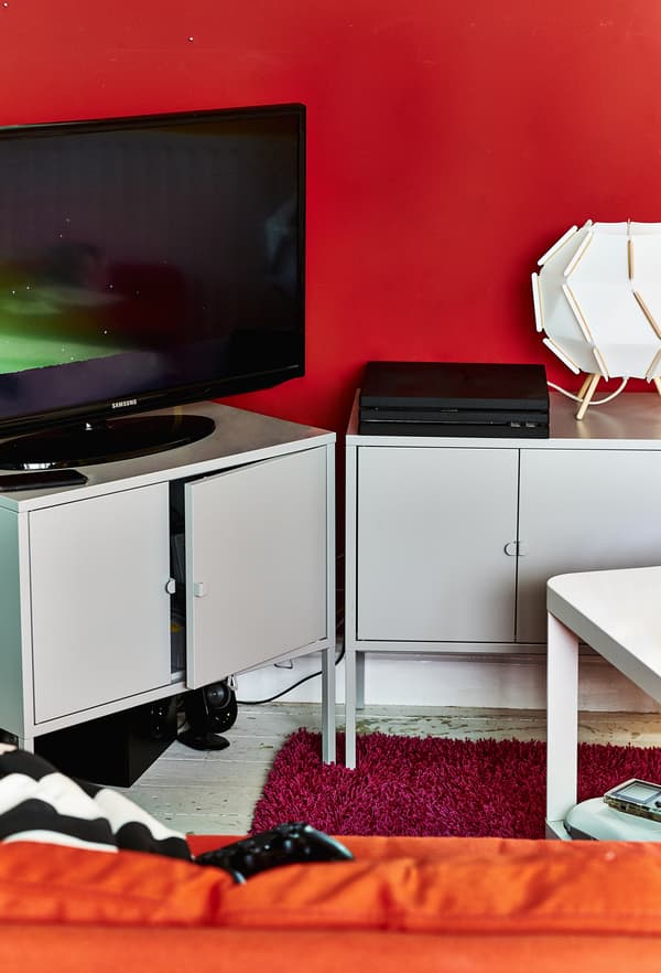 A TV and console on metal cabinets.
