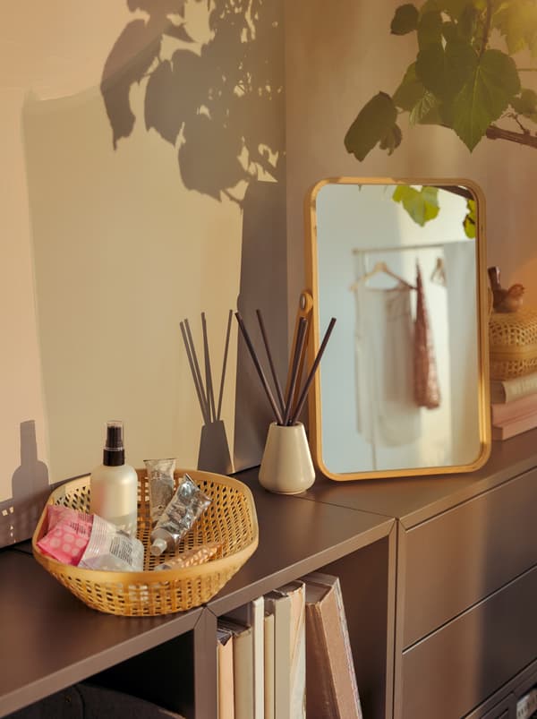 A vanity nook on top of a low bookcase is a IKORNNES mirror.