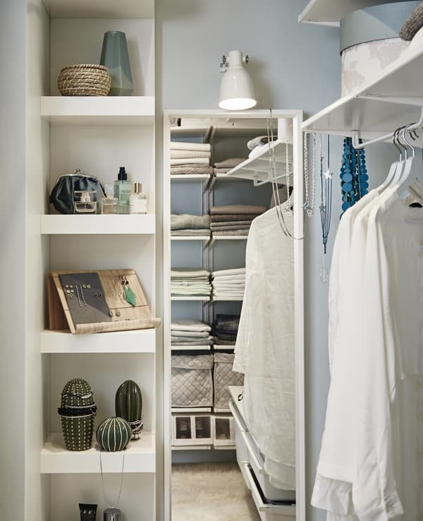 A vanity space inside the walk-in closet with a shelving unit for makeup and jewelry display together with a full-length mirror.