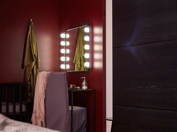 A vanity space sits across the room from the bed.