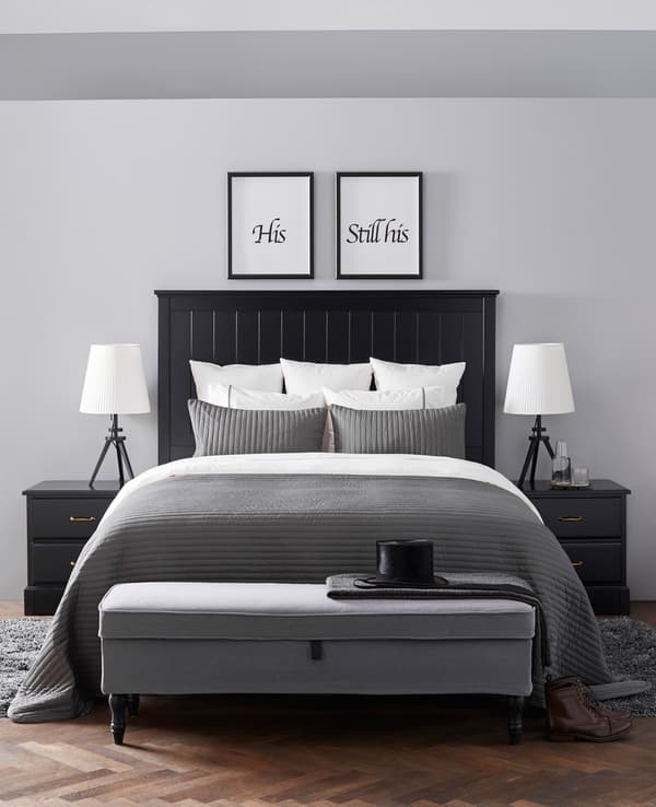 A very neat bedroom in whites, blacks, and greys is reminiscent of a hotel suite.