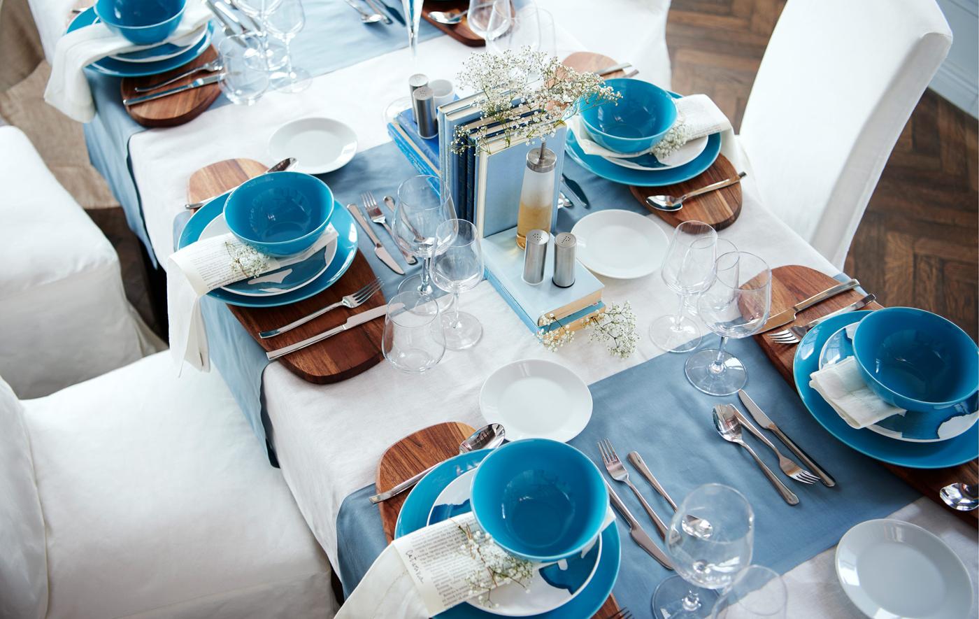 A view from above of a dining table set formally, with a white and blue colour scheme.