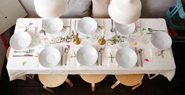 A view from above of the dinner table, fully set with flatware and cuttlery.