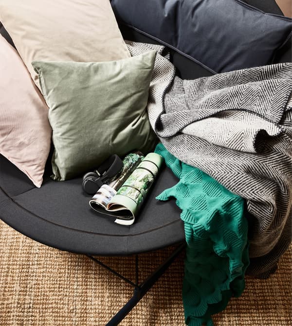 A view from above the IKEA PS 2017 rocking chair in black, filled with pillows and blankets.