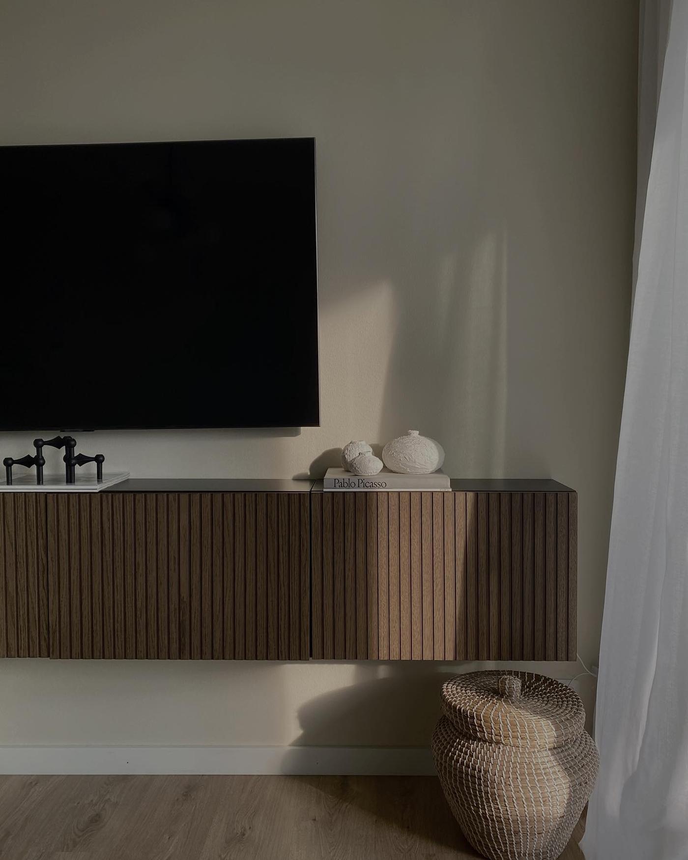 A wall‑mounted BESTÅ TV unit with dark brown walnut doors in the living room.