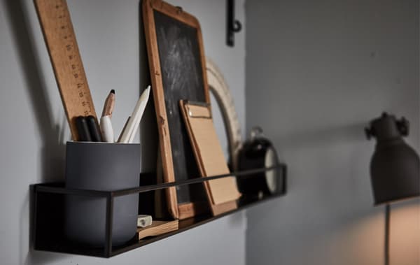A wall shelf filled with study accessories in a grey room.