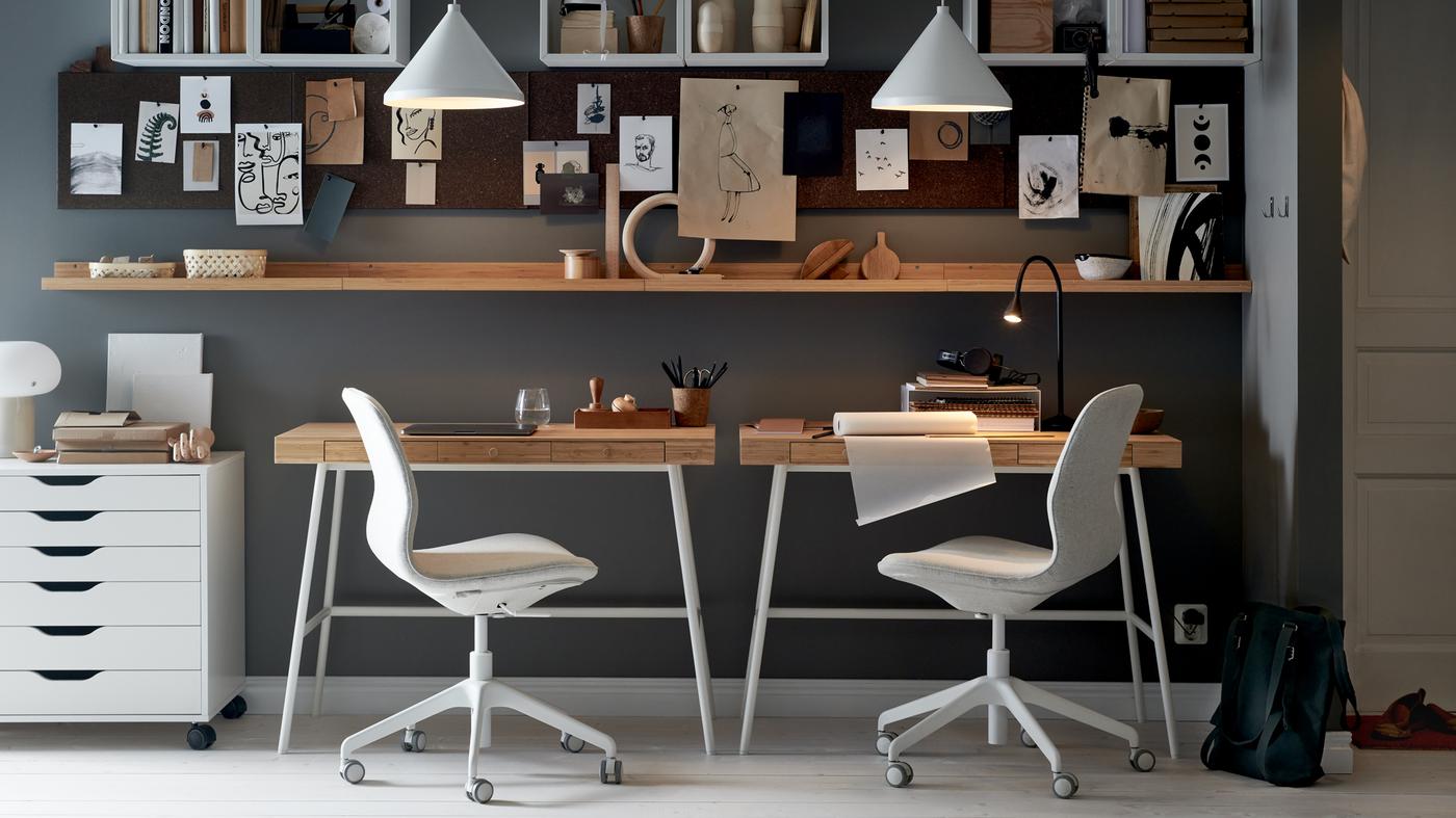 A wall with two LILLÅSEN desks, office chairs and a white drawer unit, with shelving, memo boards and white pendants.