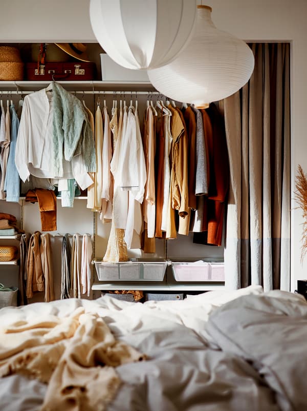 A wardrobe with curtains for “doors” and a combination of hangers and shelves for suitcases and boxes for smaller items.