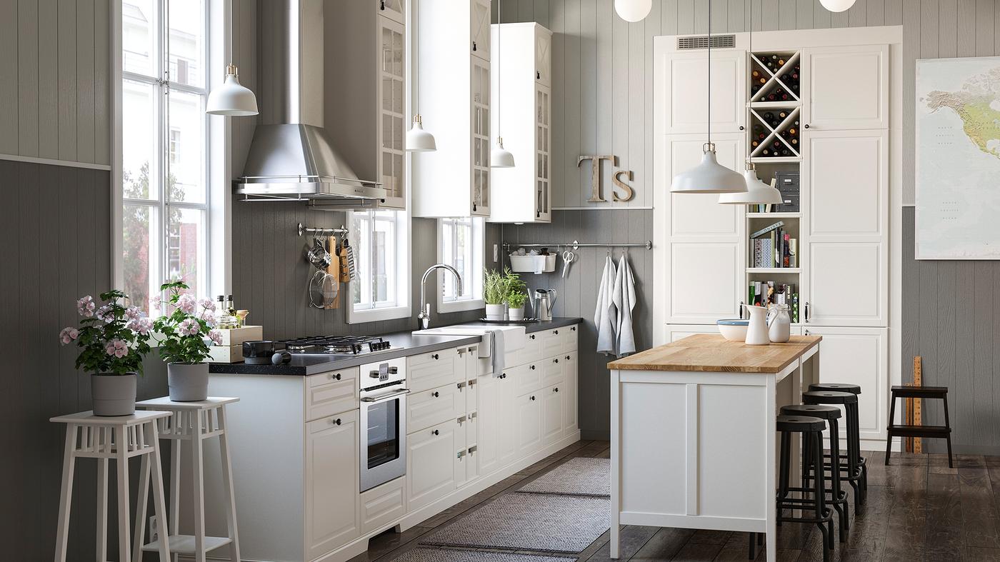 A white and grey rustic kitchen with a mix of closed and open white kitchen storage shelves and cabinets and an island.