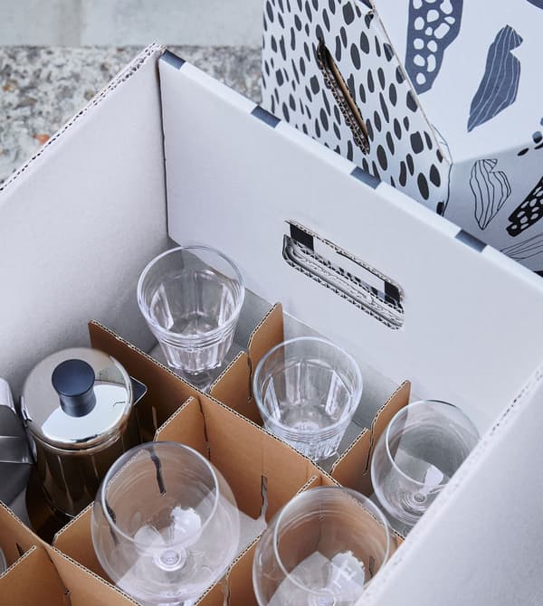 A white box with a brown OMBYTE divider, filled with a variety of clear wine glasses.