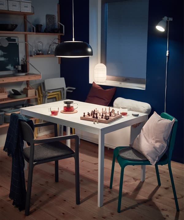 A white EKEDALEN extendable dining table being used for playing board games.