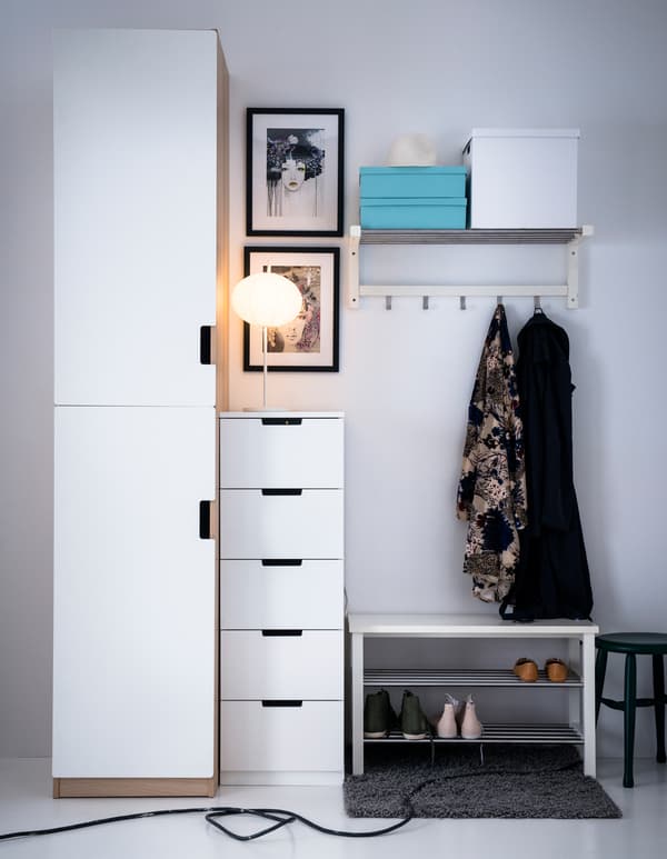A white hallway with white storage furniture, including a shoe rack, wardrobe and rail with hooks.