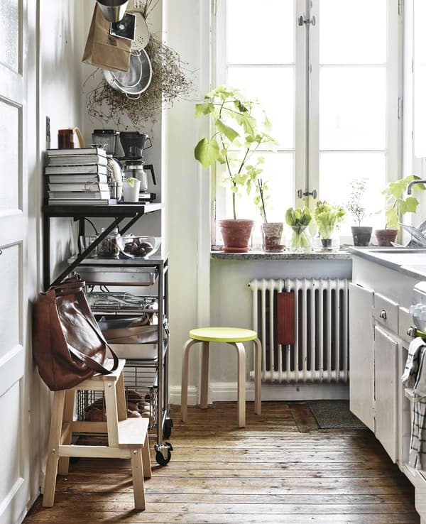 A white kitchen with open storage and a step stool.