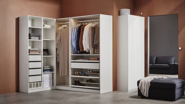 A white PAX wardrobe is filled with clothing and shoes