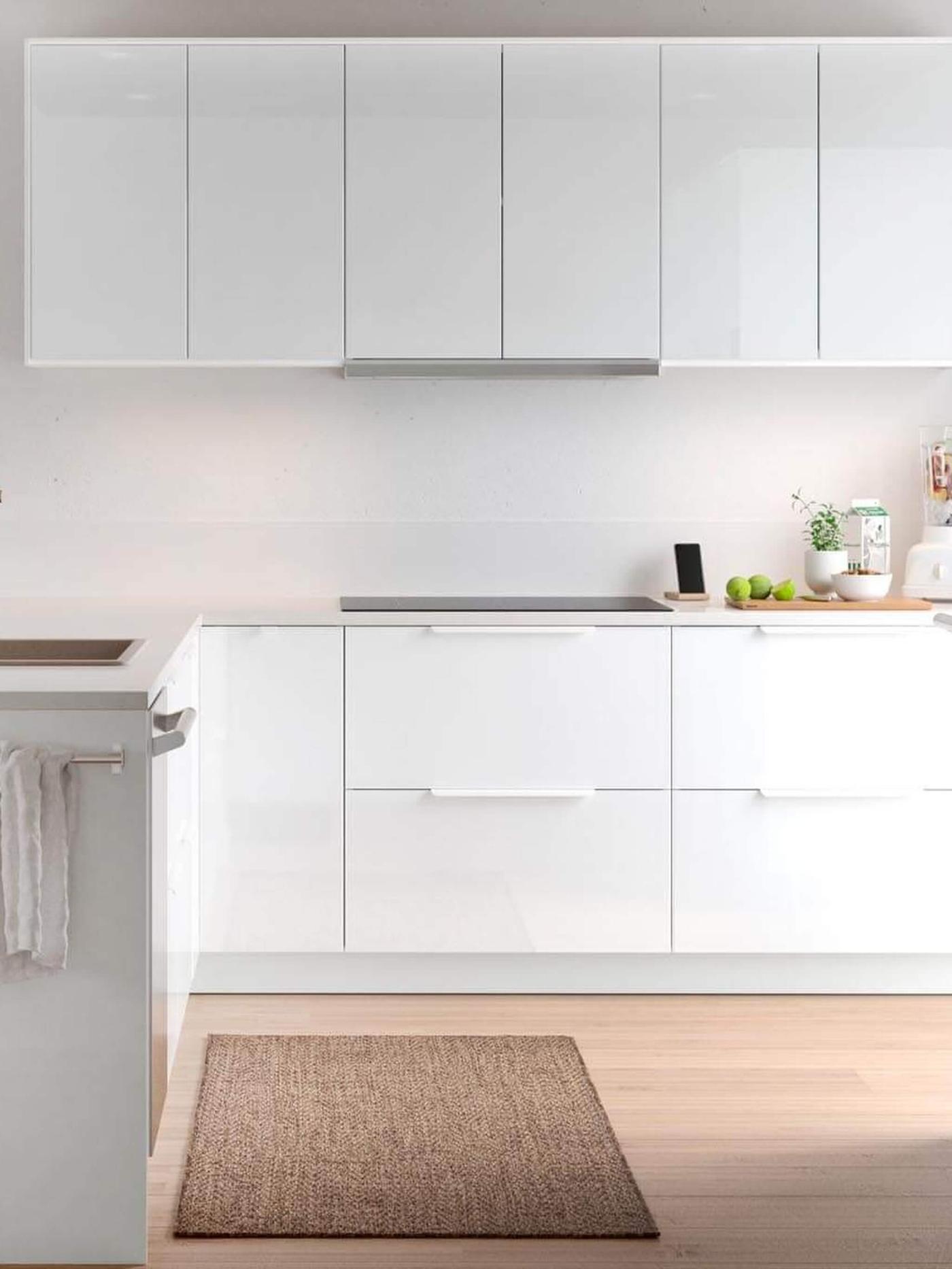 A white RINGHULT high gloss kitchen with a cutting board on the countertop.