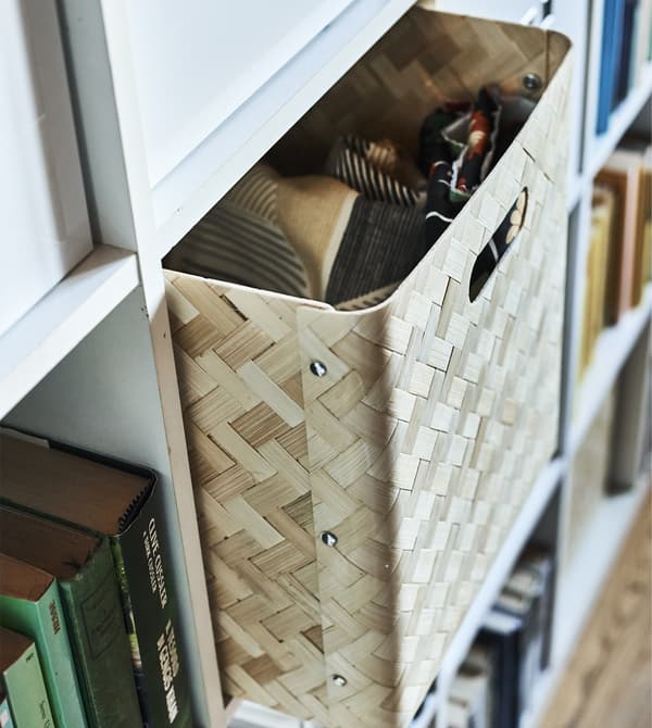 A wicker box in a white KALLAX unit.