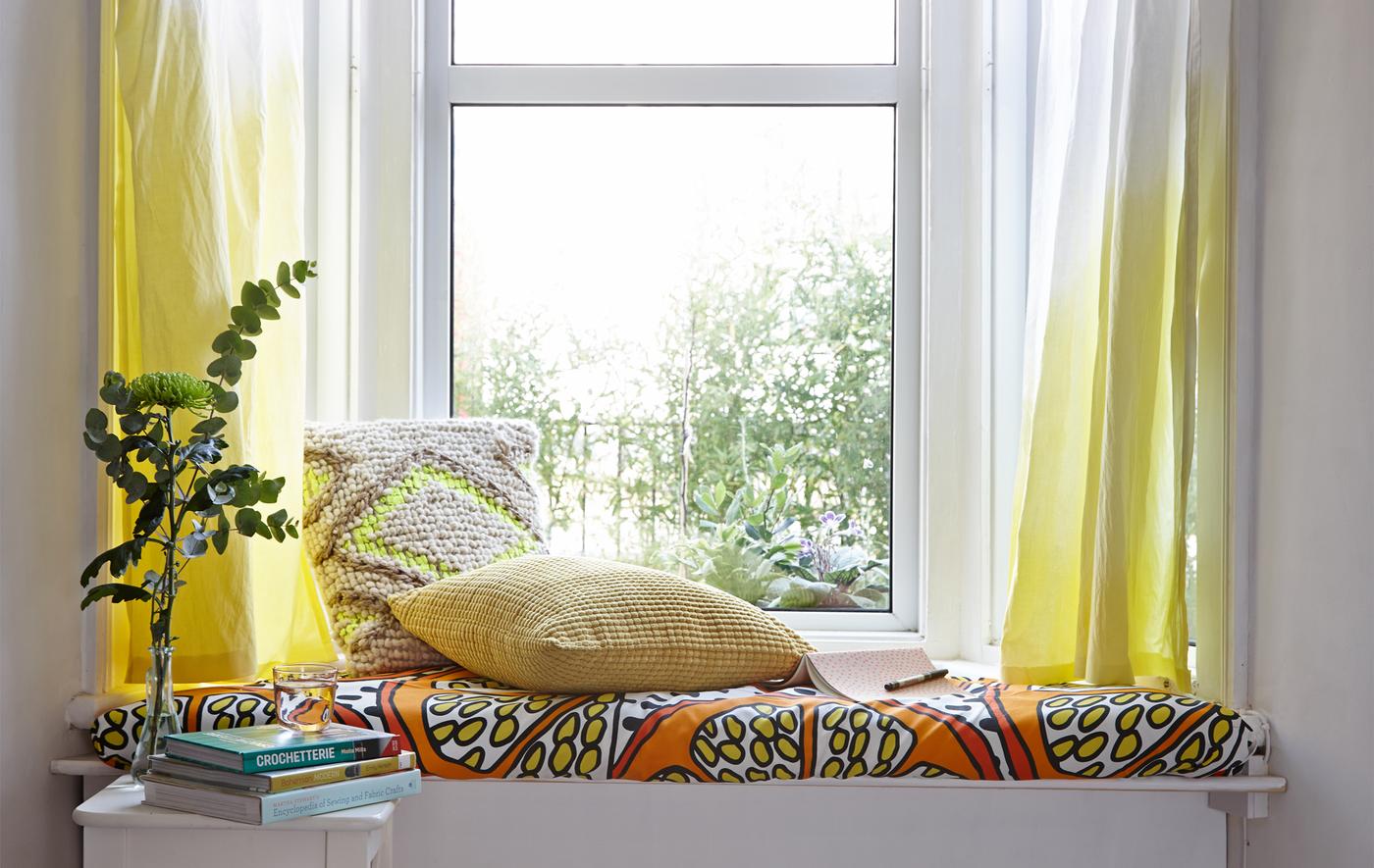 A window seat with dip-dyed curtains.
