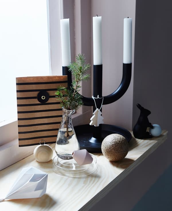 A windowsill is decorated with simple holiday decorations.