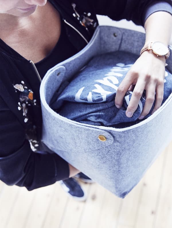 A woman holding a basket of clothes.