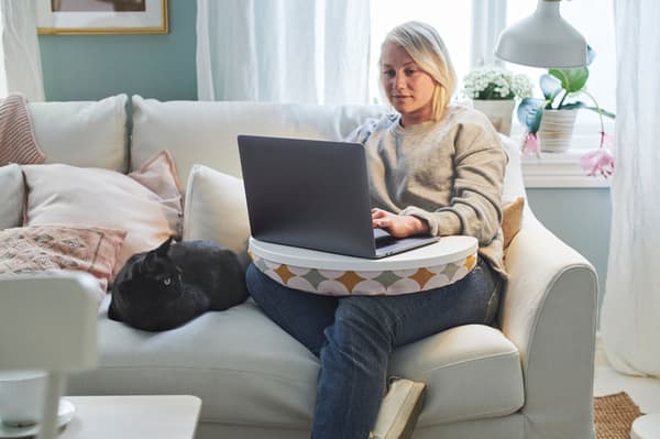 A woman sitting on a sofa with a laptop. 