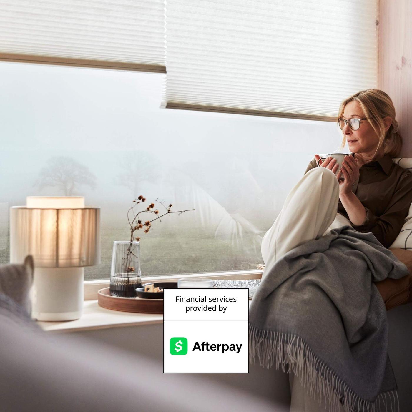 A woman sitting on a window ledge and a graph with the text "Financial service provided by Afterpay" on it.