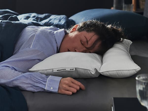 A woman sleeping on her stomach on a white pillow.
