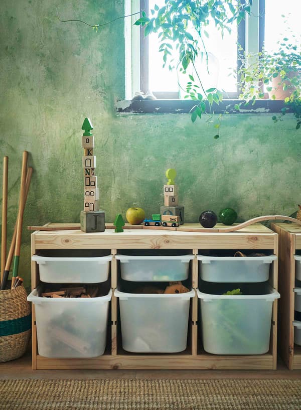 A wood-framed storage system full of childrens’ toys.