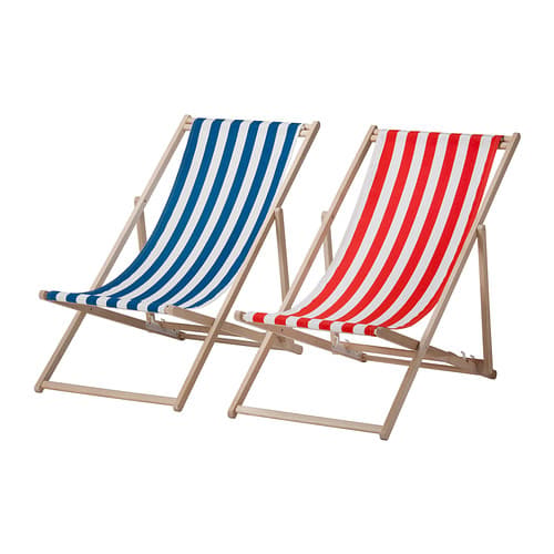 A wooden beach chair with a blue and white striped fabric seat next to one with a red and white striped seat.