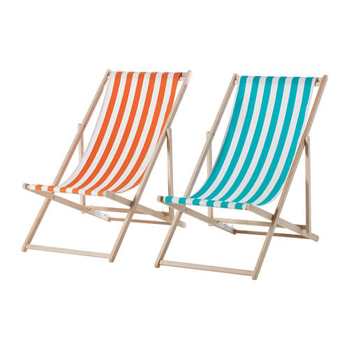 A wooden beach chair with an orange and white striped fabric seat next to one with a blue and white striped seat.