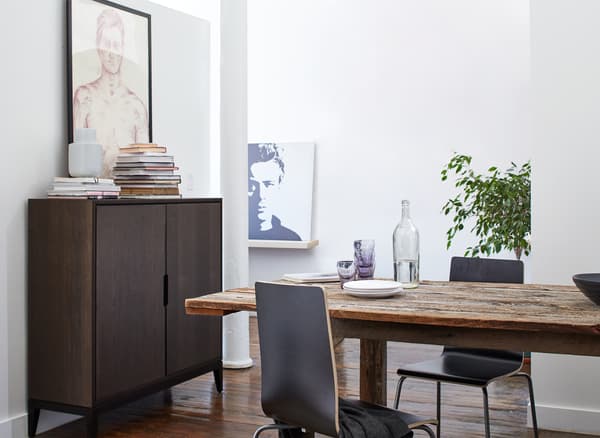 A wooden dining table and brown cabinet in a dining area.