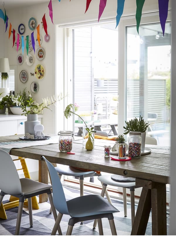 A wooden dining table with colourful bunting.
