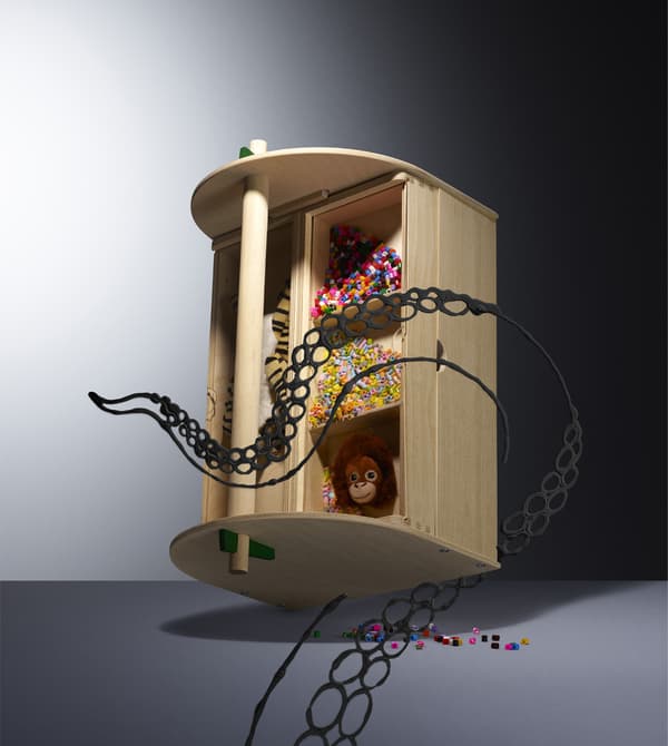 A wooden storage box filled with colourful beads and toys