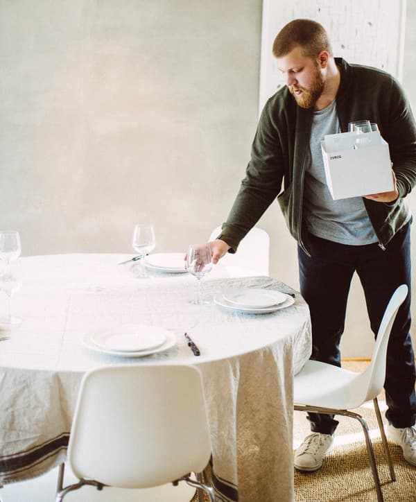 A young man setting a table as part of a “matlag” or food club.